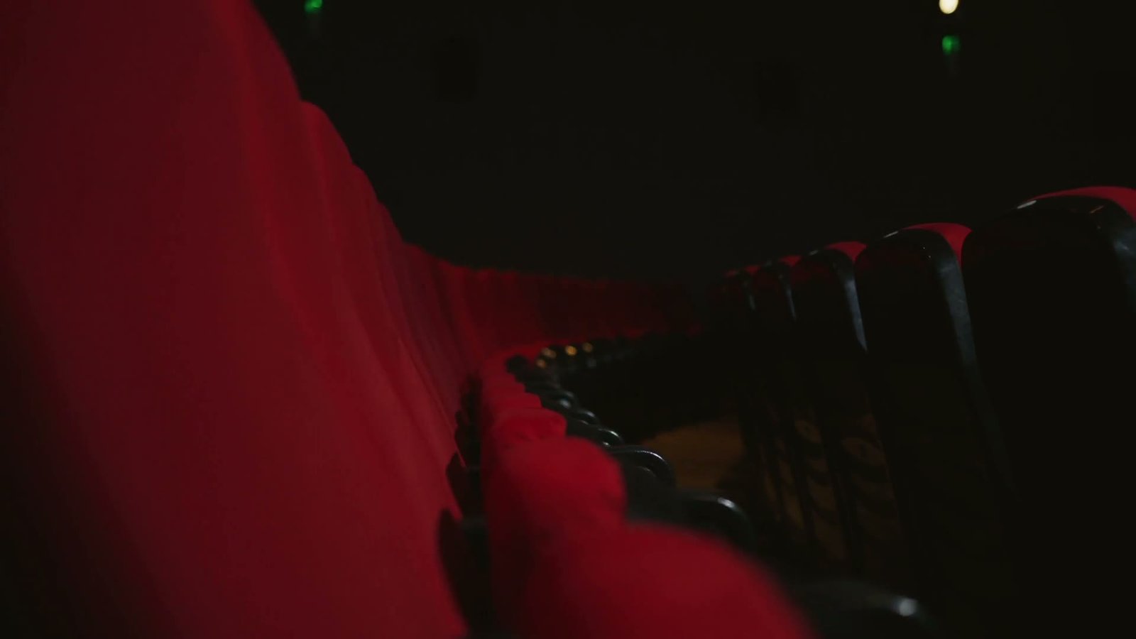 Illustrative red cinema seats before a screening